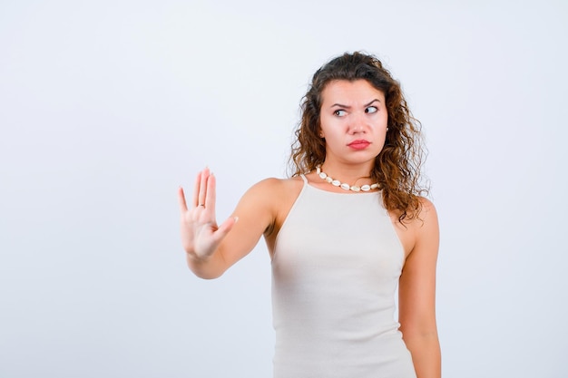 Guardando a sinistra la ragazza sta mostrando il gesto di arresto su sfondo bianco