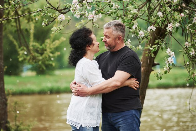 Guardandoci con amore. Coppie allegre che godono del fine settimana piacevole all'aperto. Bel tempo primaverile