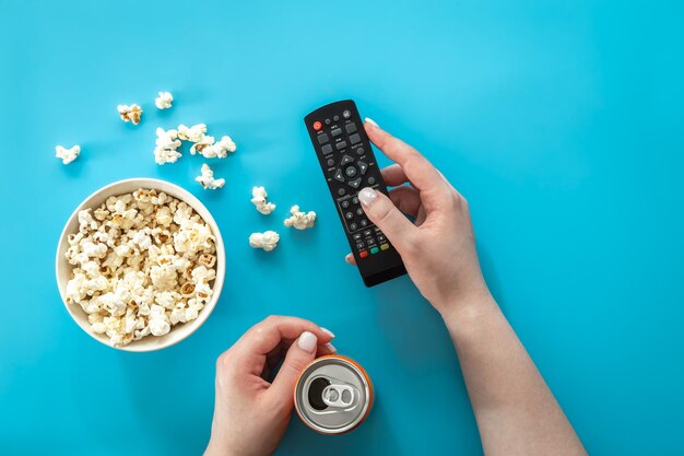 Guardare film con popcorn su sfondo blu piatto