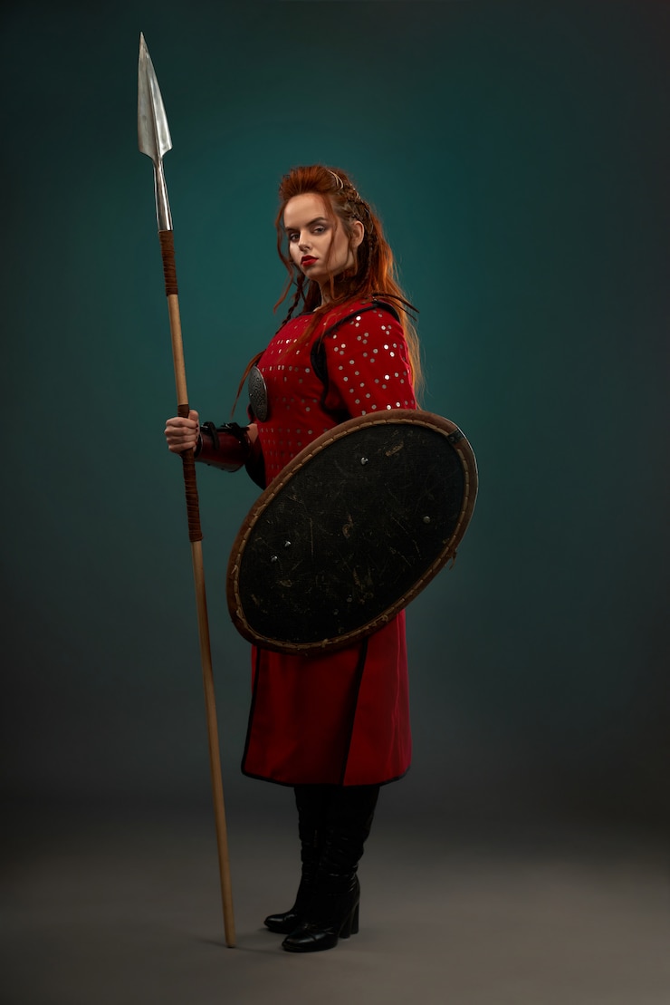 Foto gratuito guerriero coraggioso della donna con l'arma che posa nello studio.