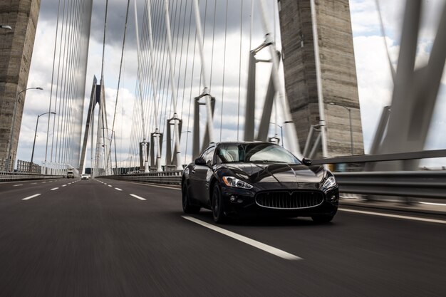 Guida di berlina nera che guida sulla strada del ponte.