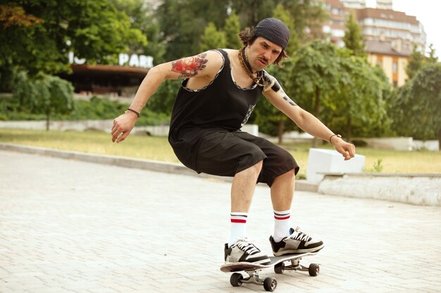 Guidatore di skateboard facendo un trucco per la strada della città in una giornata nuvolosa