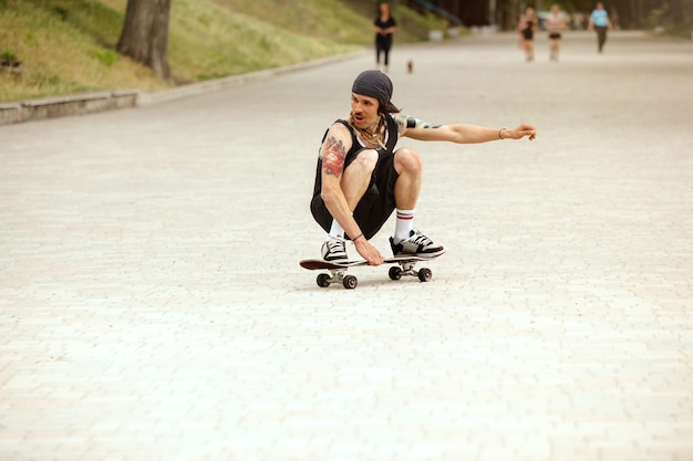 Guidatore di skateboard facendo un trucco per la strada della città in una giornata nuvolosa