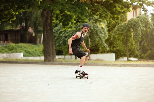 Guidatore di skateboard facendo un trucco per la strada della città in una giornata nuvolosa