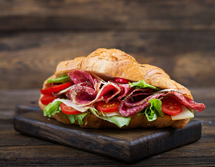 Foto gratuito gustosa colazione croissant appetitoso con salame e formaggio e pomodori