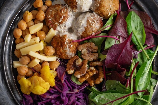 Gustosa insalata vegetariana vegana con ceci, falafel e foglie servita sul piatto.