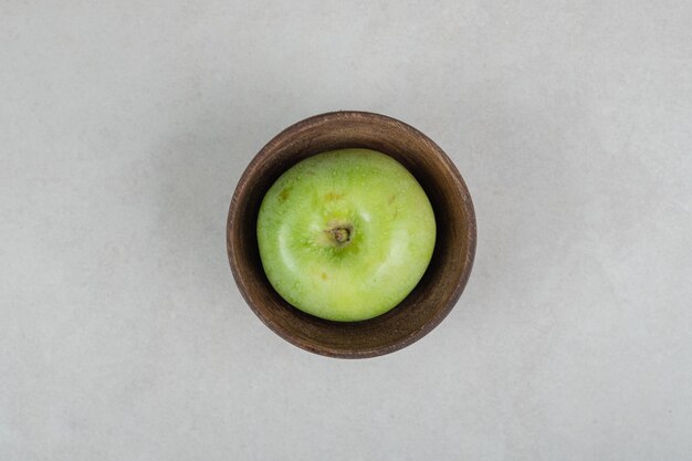 Gustosa mela verde in ciotola di legno
