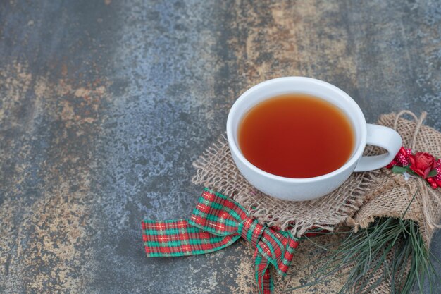 Gustosa tazza di tè con bellissimo fiocco su tela.
