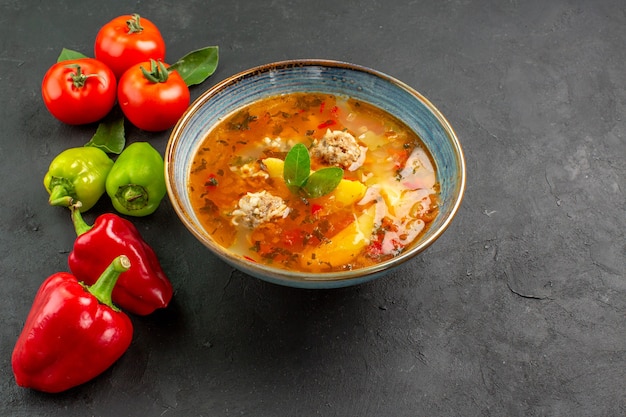 Gustosa zuppa di polpette di carne vista dall'alto con verdure sui colori del piatto di salsa di tavola scura