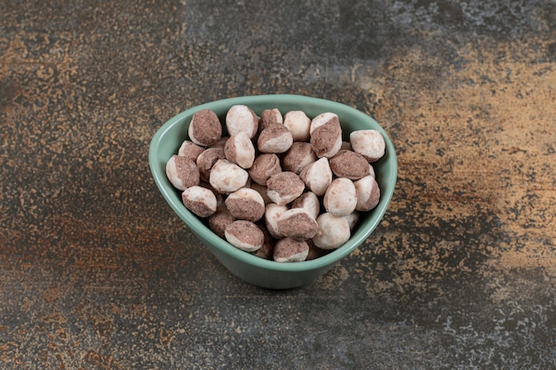 Gustose caramelle marroni in ciotola blu.