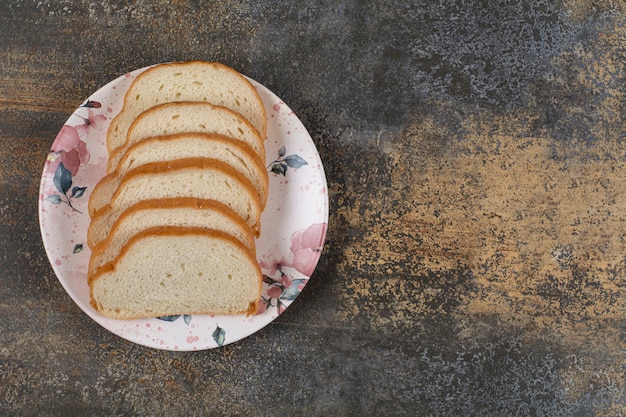 Gustose fette di pane bianco sul piatto colorato.