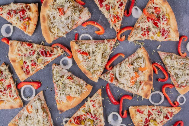 Gustose fette di pizza sul blu con anelli di cipolla e pepe.