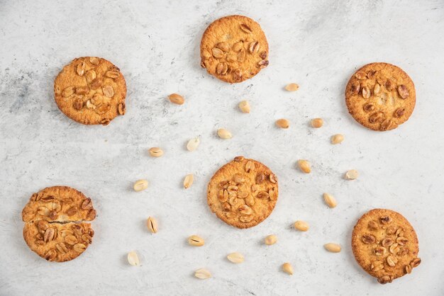 Gustosi biscotti con arachidi organiche e miele sul tavolo di marmo.