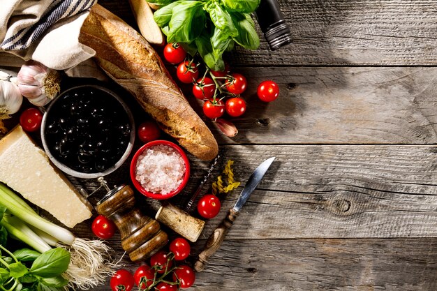 Gustosi ingredienti alimentari freschi appetitosi per cucinare sul vecchio sfondo rustico di legno.