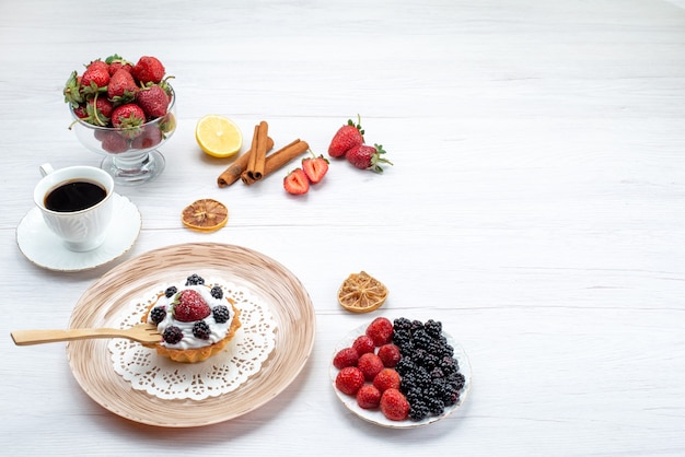 gustosissima torta cremosa con frutti di bosco insieme a una tazza di cannella di bacche di caffè sulla scrivania luminosa, torta dolce colore bacca