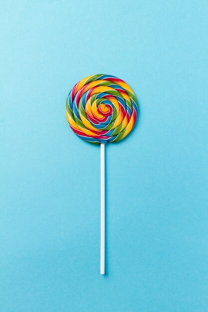 Gustoso appetitoso partito accessorio Sweet Swirl Candy Lollypop su sfondo blu Top View