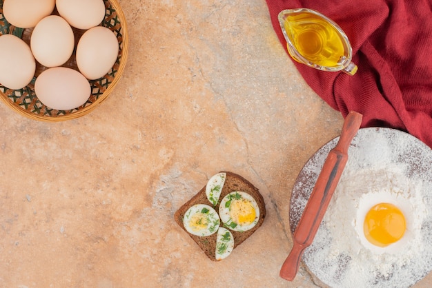 Gustoso toast con diverse uova e olio su tavola di marmo.