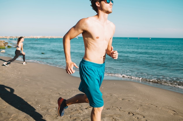 Guy che fa jogging in spiaggia