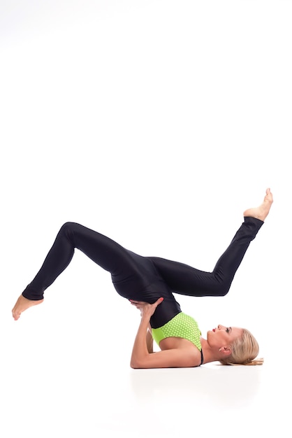 Ha il suo equilibrio. Studio verticale di una ginnasta in forma che fa un supporto per le spalle con le gambe sollevate in aria copyspace sopra isolato