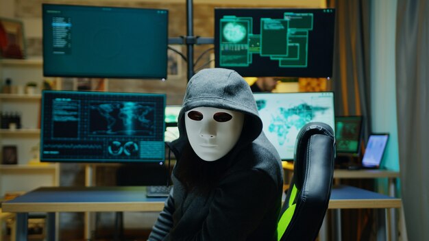 Hacker mascherato che indossa una felpa con cappuccio per nascondere la sua identità. criminale di Internet.
