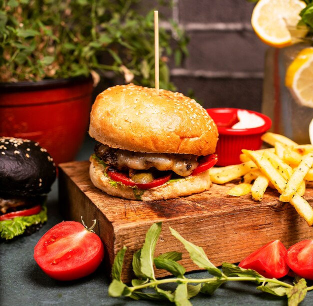 Hamburger al formaggio di manzo con verdure, fast food, patatine fritte e ketchup