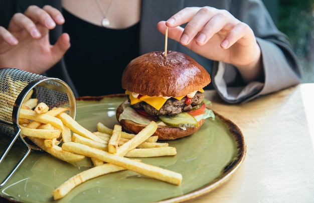 Hamburger appetitoso del primo piano e patatine fritte in un caffè