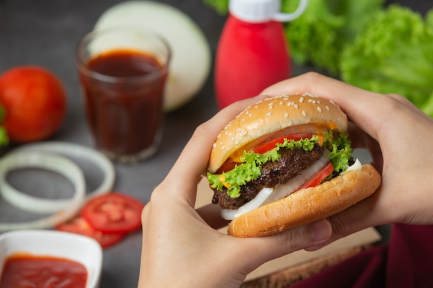 Hamburger con carne fritta, pomodori, sottaceti, lattuga e formaggio.