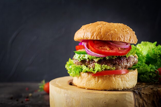 Hamburger con hamburger di carne di manzo e verdure fresche sul tavolo scuro. Cibo gustoso.