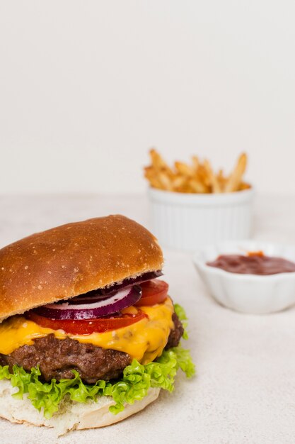 Hamburger con le fritture sulla tavola bianca