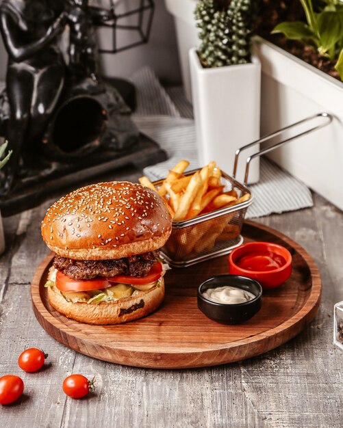 Hamburger con panino al sesamo e patatine fritte