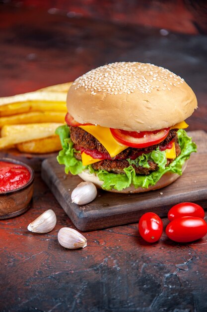 Hamburger di carne di vista frontale con insalata di formaggio e pomodori sul pavimento scuro