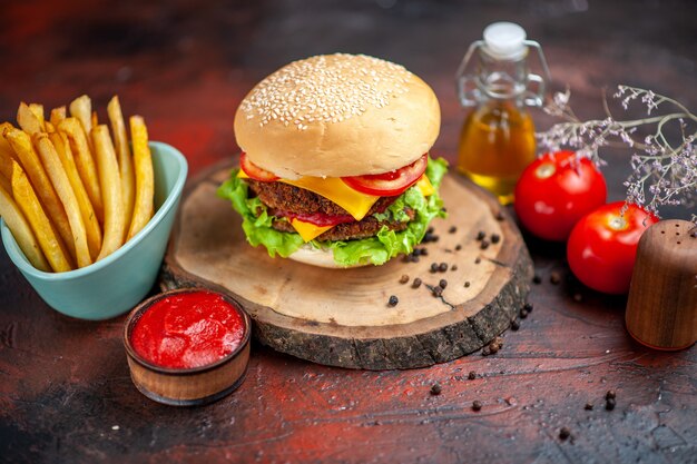 Hamburger di carne vista frontale con patatine fritte sulla scrivania scura