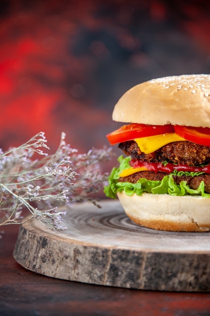 Hamburger di carne vista frontale con pomodori al formaggio e insalata su sfondo scuro