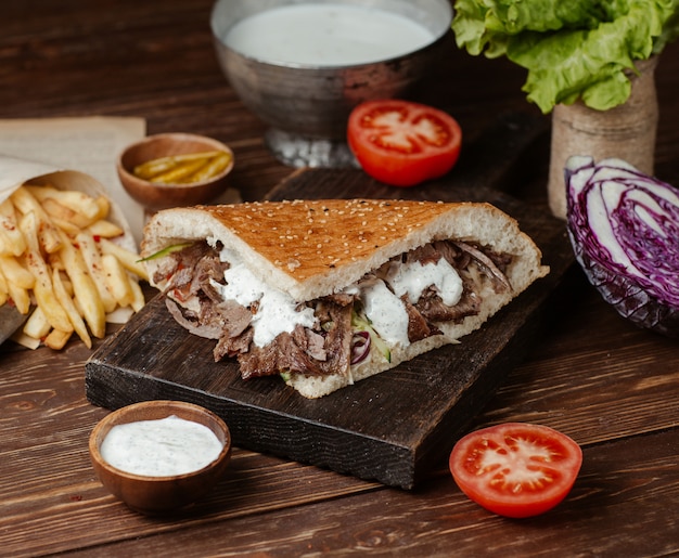 Hamburger di doner nel pane con patatine fritte