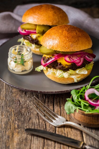 Hamburger di manzo ad alto angolo con sottaceti sul tagliere