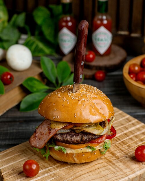 Hamburger di manzo con insalata di pomodori e peperoni e cipolla caramellata