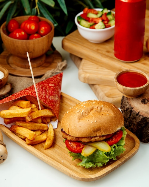 Hamburger di pollo con patatine fritte sul tavolo