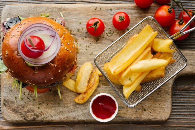 Hamburger e patatine fritte su tavola di legno