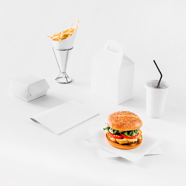 Hamburger fresco; patatine fritte; pacchi e tazza di smaltimento su sfondo bianco
