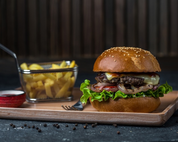 Hamburger grande con patatine arrosto.