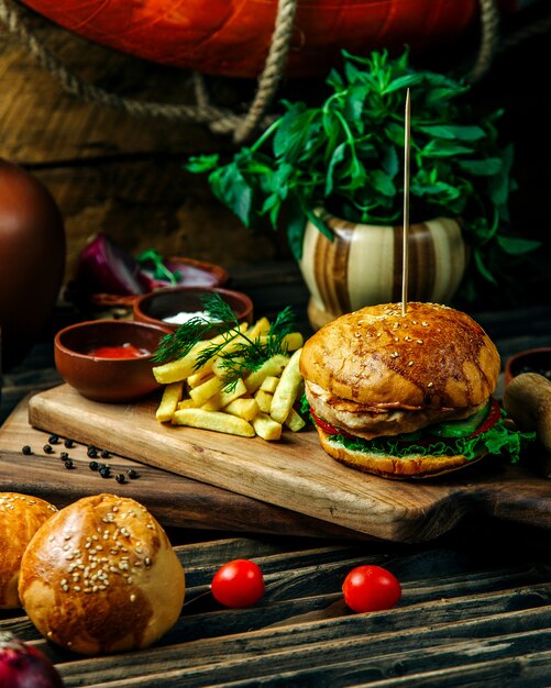 Hamburger servito con erbe e patatine fritte