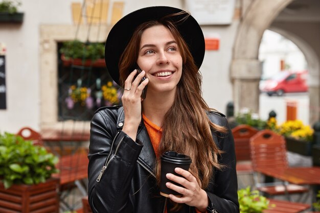 Headshot di bella femmina allegra felice di sentire il vecchio amico tramite telefono cellulare, ha viaggio all'estero