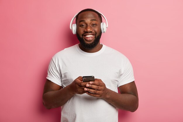 Hipster maschio ascolta musica in cuffie wireless isolate