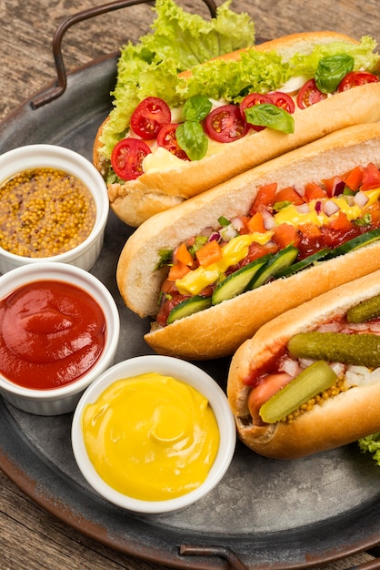 Hot dog ad angolo alto e contenitori per salse