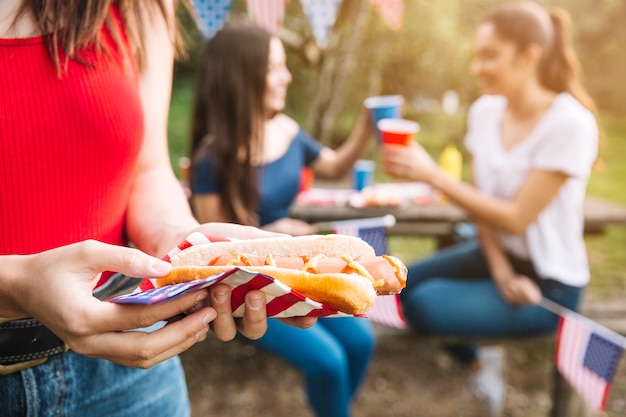 Hot dog della holding della donna sul picnic