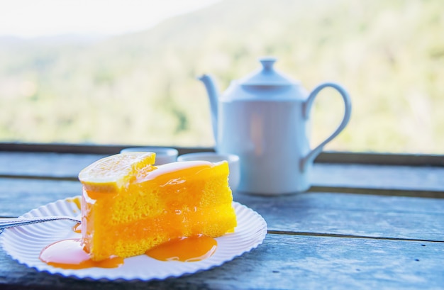 Hot mangiare tazza e torta arancia con sfondo verde natura