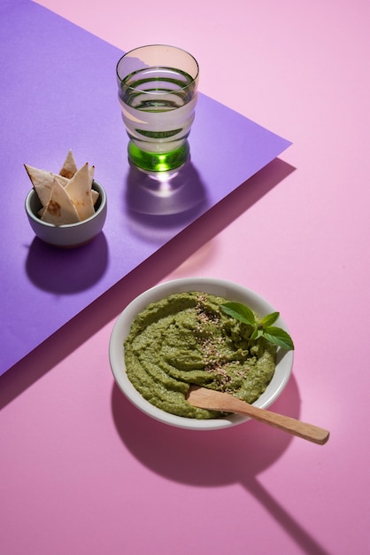 Hummus ad alto angolo e bicchiere d'acqua