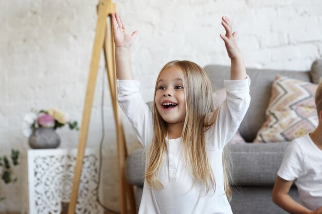 I bambini espressivi stanno posando in casa