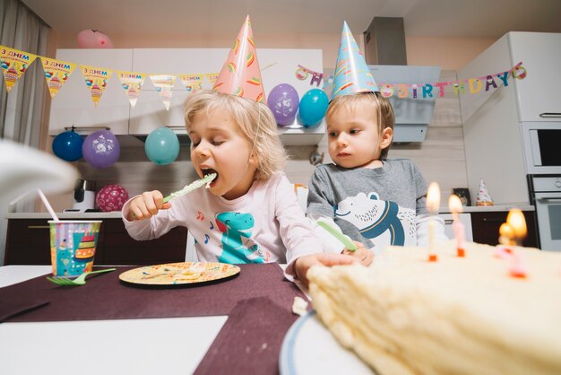 I bambini mangiano la torta sulla festa di compleanno