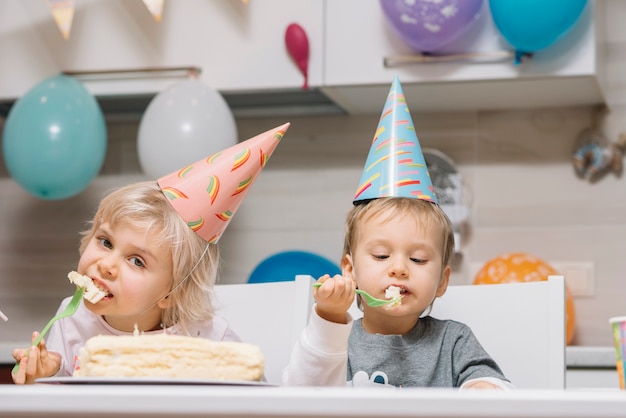 I bambini mangiano la torta sulla festa di compleanno